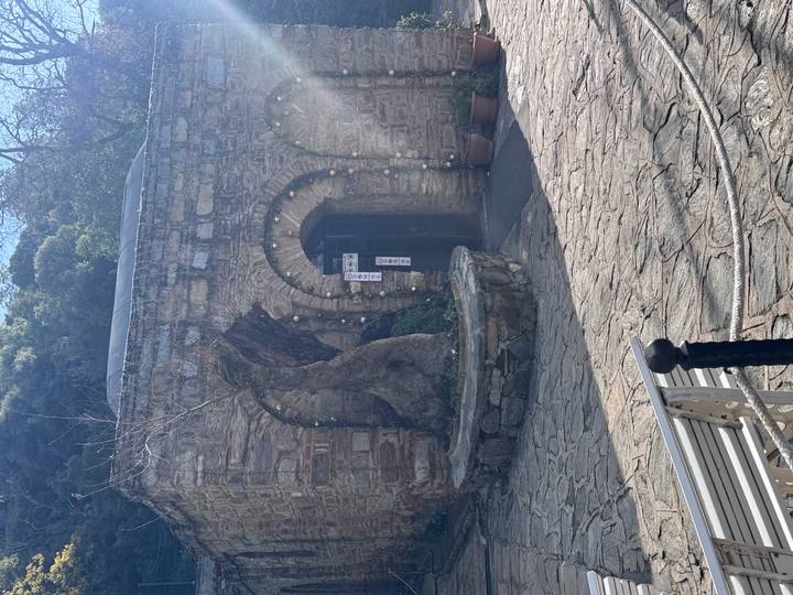 Entrada de arco de piedra a un pequeño edificio histórico.