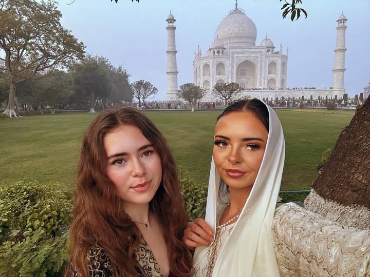 Dos personas posando frente al Taj Mahal.