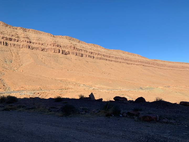 Vaste paysage désertique avec une colline rocheuse escarpée.