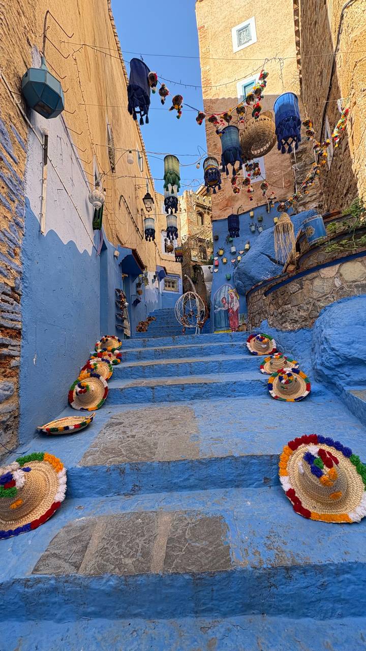 Marches peintes en bleu avec des chapeaux traditionnels à Chefchaouen.