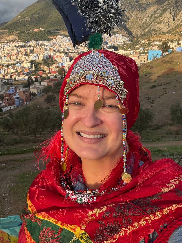 Personne souriante vêtue d'un habit traditionnel marocain.