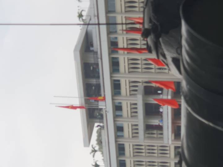 Edificio con banderas en la parte superior visto desde la distancia.