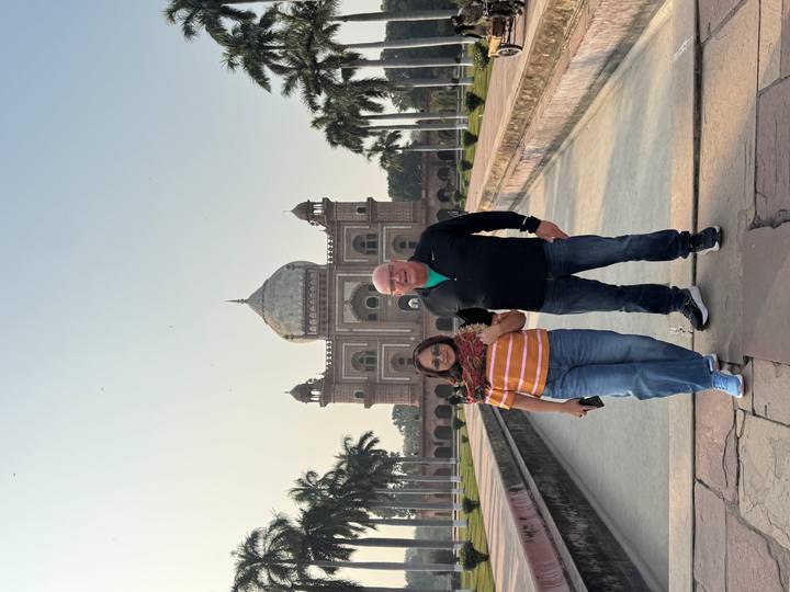 Pareja de pie frente a un gran edificio con cúpula.