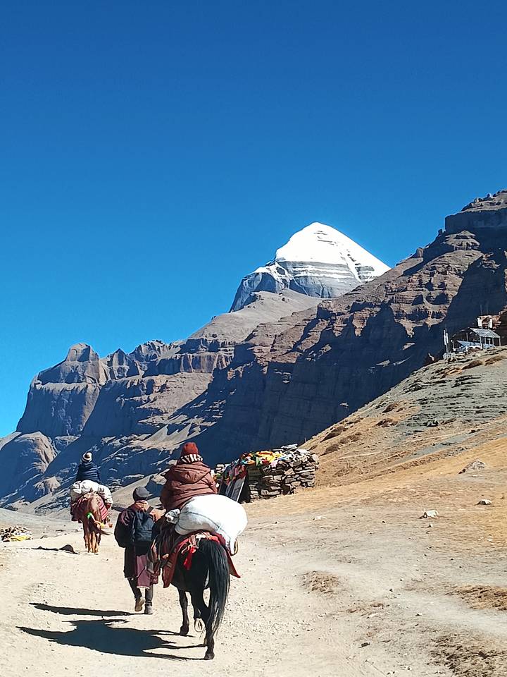 Personas con vista panorámica del Monte Kailash al fondo.