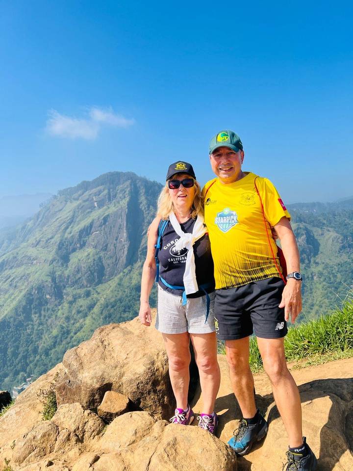 Deux randonneurs posant avec un paysage montagneux en arrière-plan.