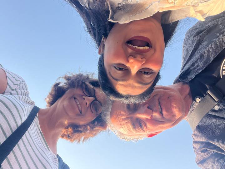 Tres personas sonriendo, fotografiadas desde abajo.