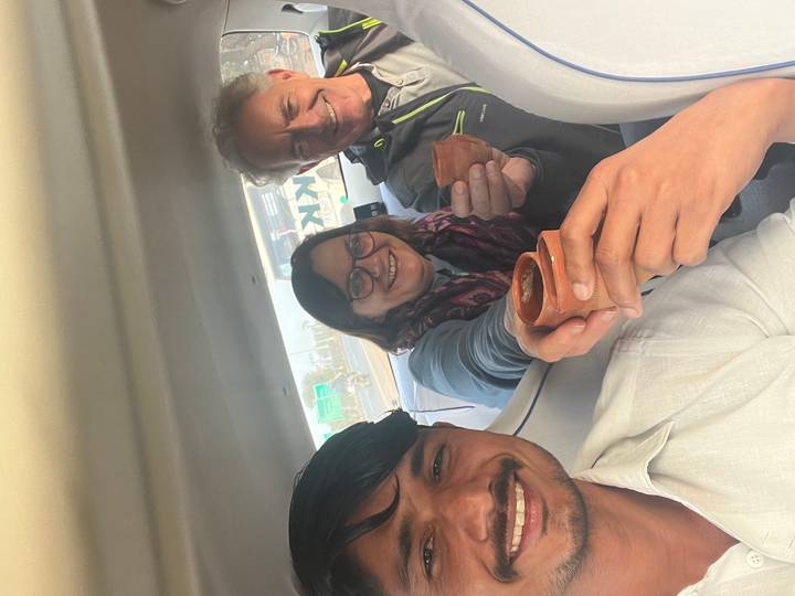 Tres personas dentro de un carro con tazas tradicionales de arcilla.