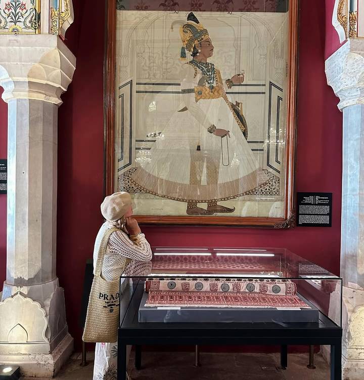 Persona admirando un retrato grande dentro de una galería de arte.