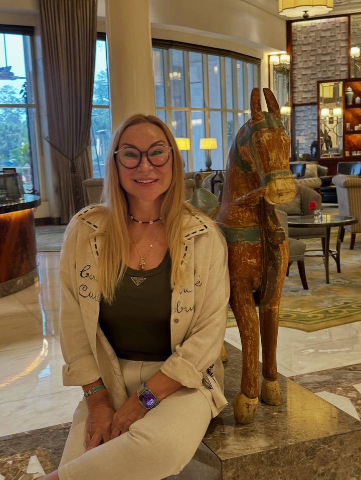 Persona dentro de un interior lujoso junto a una escultura de caballo de madera.