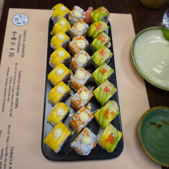 Gros plan de rouleaux de sushi colorés dans une assiette.