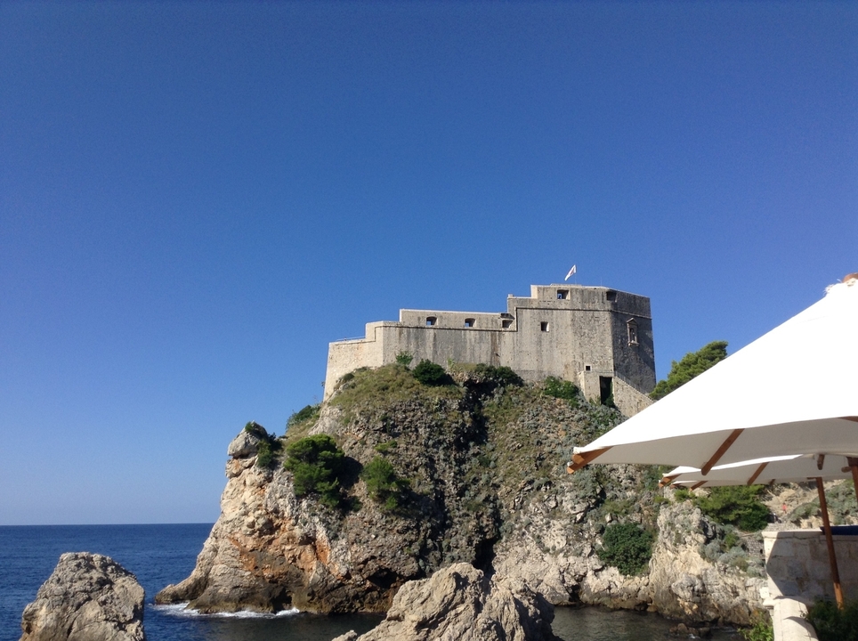 Fortress on a rocky cliff with blue sky background.