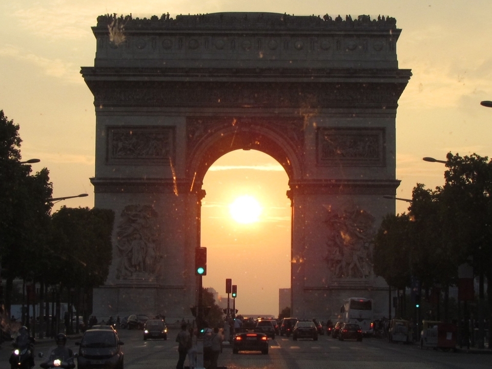 Iconic arch with the sun setting behind it.