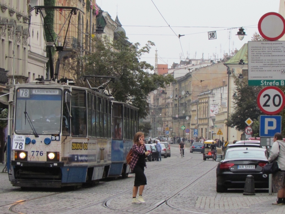 A city tram and people on a busy street.