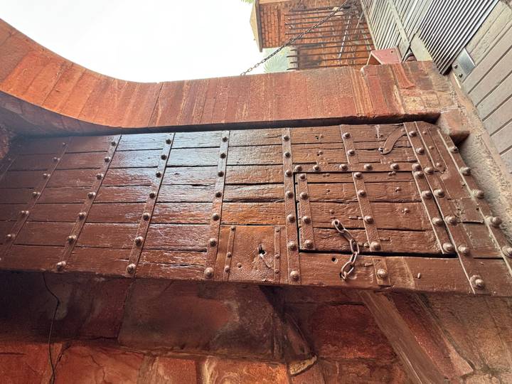 Une grande porte en bois avec des renforts métalliques.