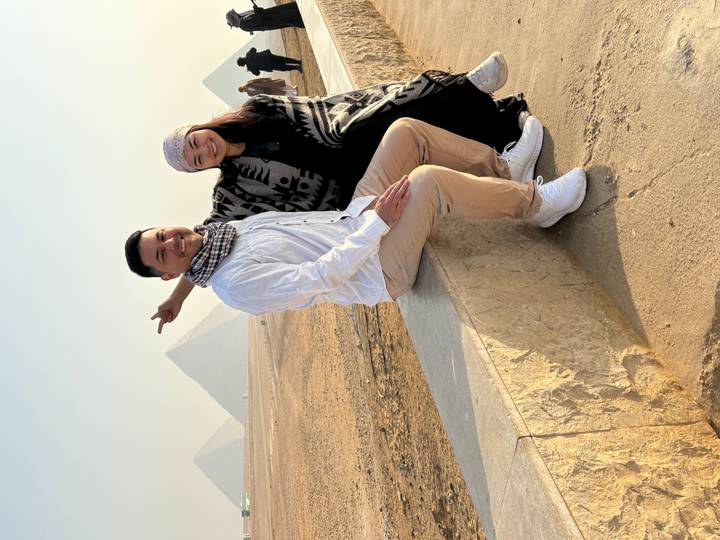 Couple assis sur un rebord avec des pyramides en vue