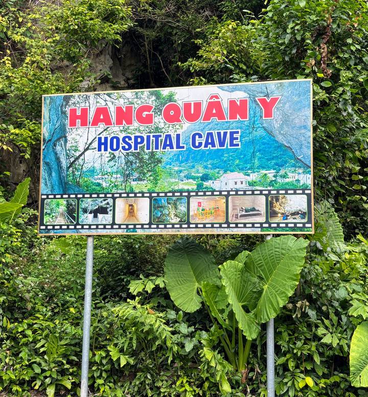 Letrero del Hospital Cueva Hang Quan Y con entorno natural verde.