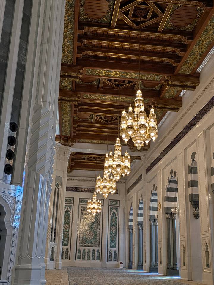 Vista interior con candelabros ornamentados y techos ricamente decorados.