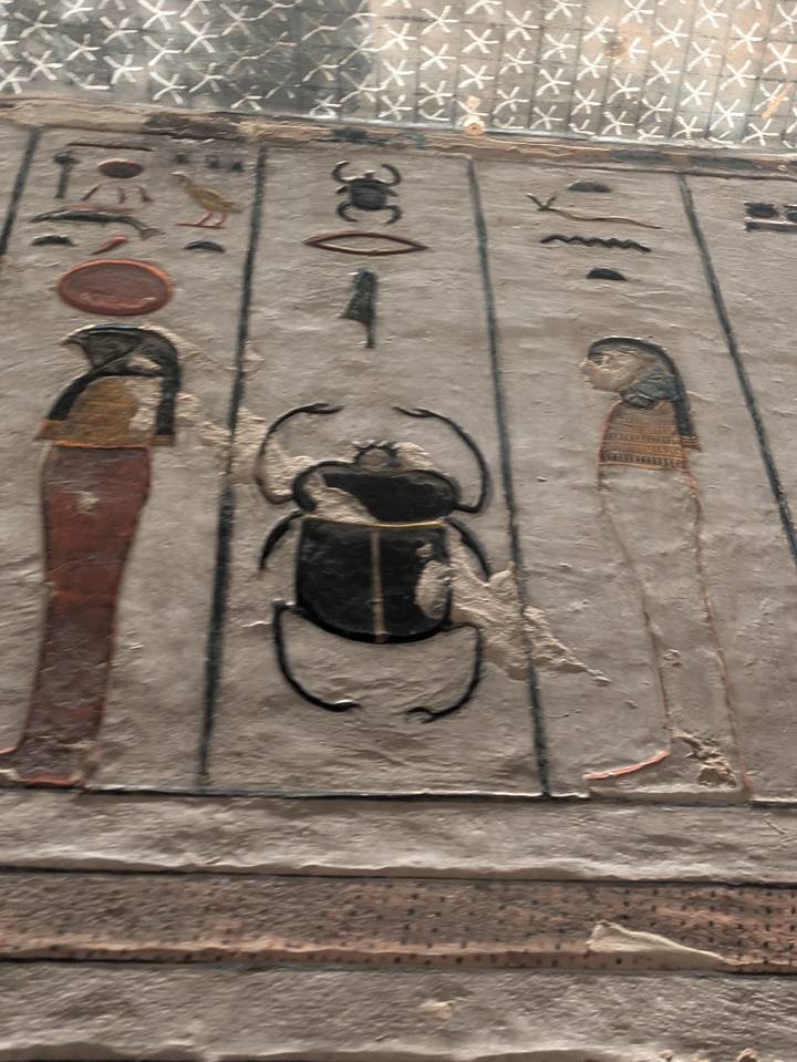 Primer plano de una pared antigua con tallados egipcios.