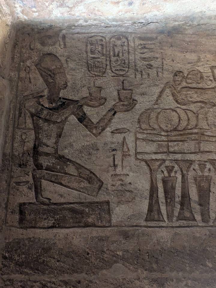 Primer plano de una antigua pared de piedra con grabados egipcios.