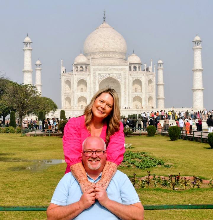 Pareja posando frente al Taj Mahal.