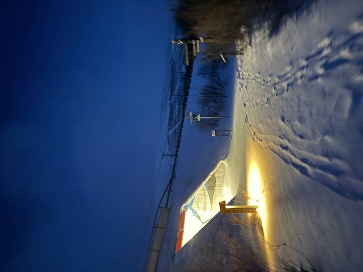 Snowy path with faint lighting at twilight.
