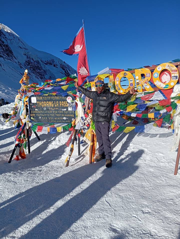 Dos personas levantando las manos en un paso nevado con símbolos de oración.