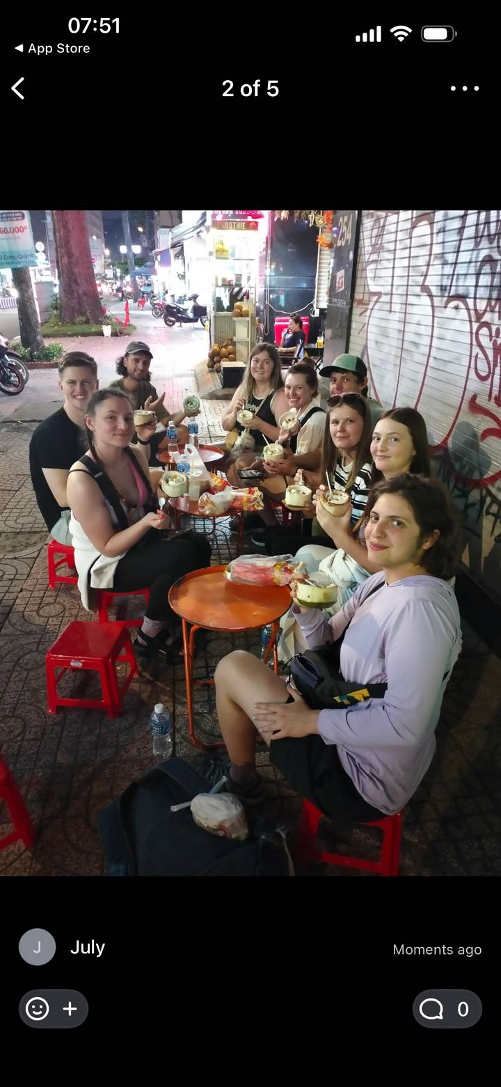 Grupo disfrutando bebidas de coco en un lugar local.