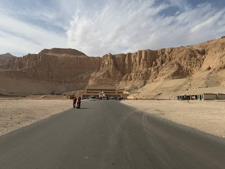 Turistas explorando un sitio histórico con estructuras monumentales de piedra.