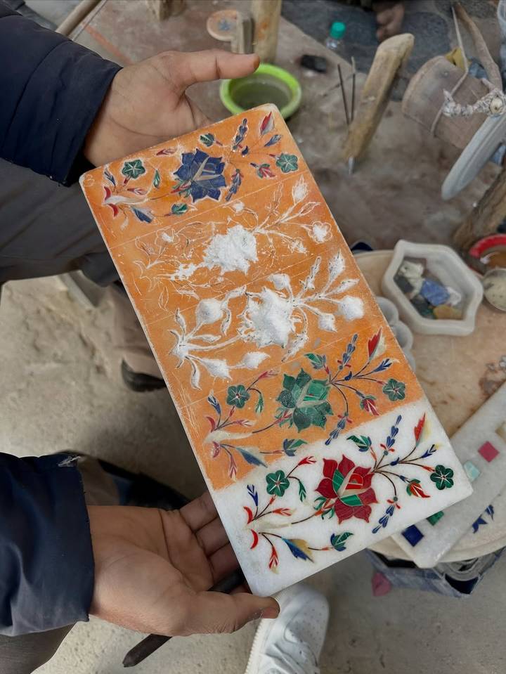 Pieza de arte de mármol con incrustaciones y patrones florales coloridos