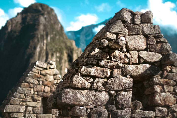 Stacked stone structures with majestic mountains in the background.