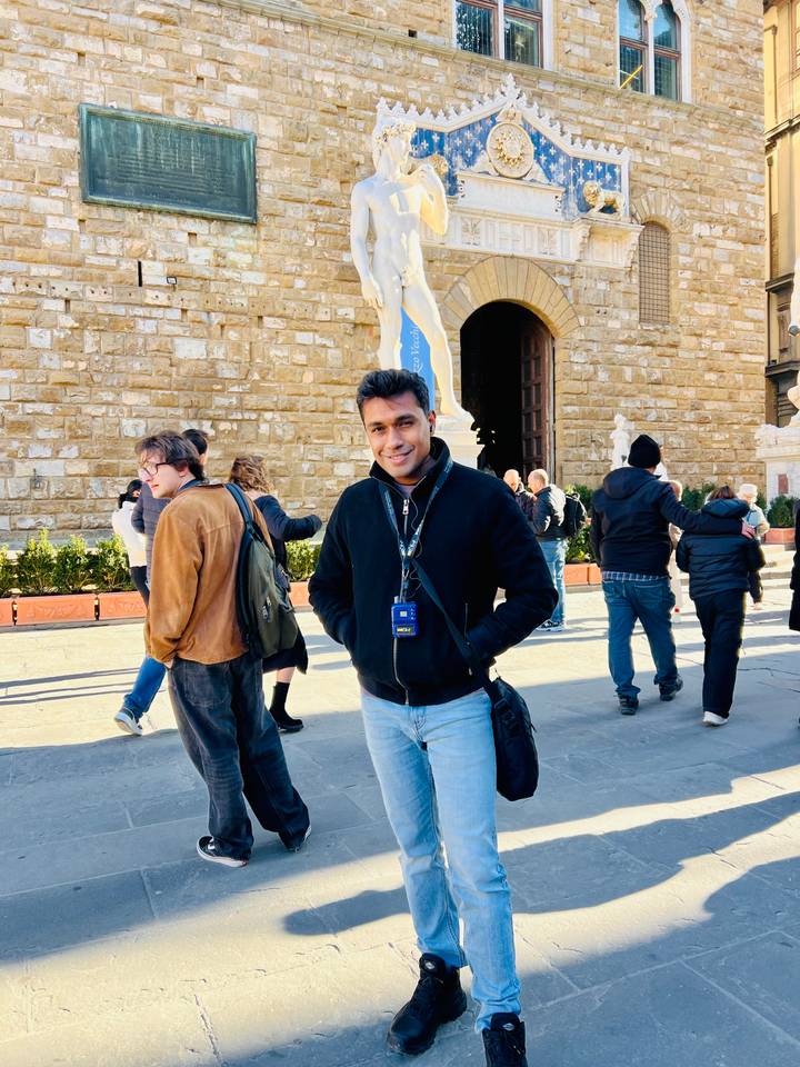 Un hombre joven posando frente a un edificio histórico en Florencia.