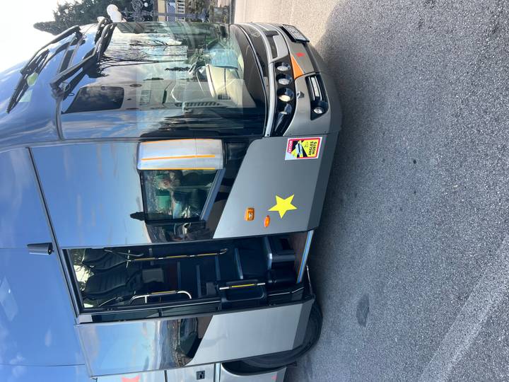 Autobús turístico estacionado en la carretera con una vista panorámica.