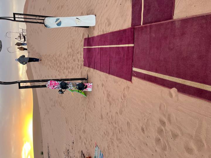 Sandboarding activity in the desert during sunrise.