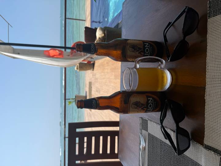 Zwei Flaschen Bier auf einem Tisch am Meer.
