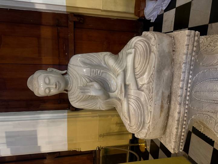 Weiße Marmor-Buddha-Statue drinnen.