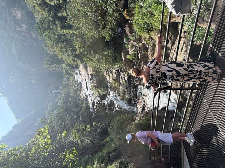 Touristen in einer felsigen Landschaft mit einem Wasserfall.