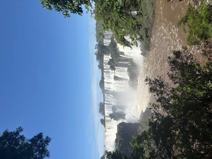 View of Iguazu Falls with clear blue skies and lush greenery.