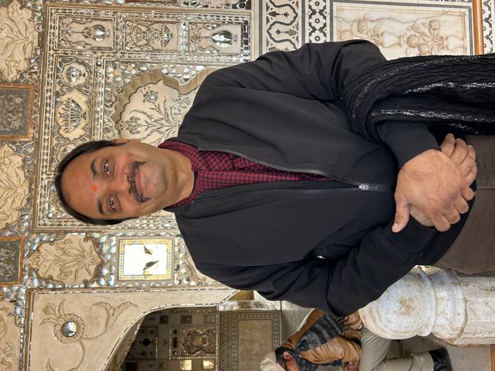 Portrait of a smiling man in front of intricate designs.