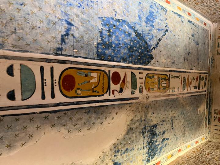 Ancient Egyptian hieroglyphs on a decorated ceiling.