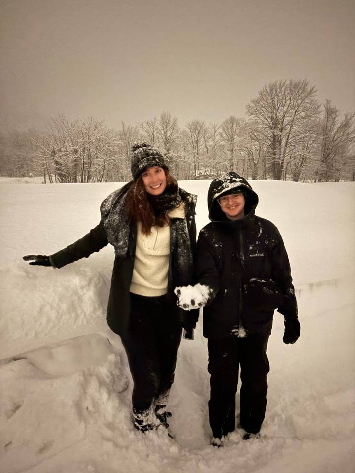 Smiling couple posing in snow-covered landscape.