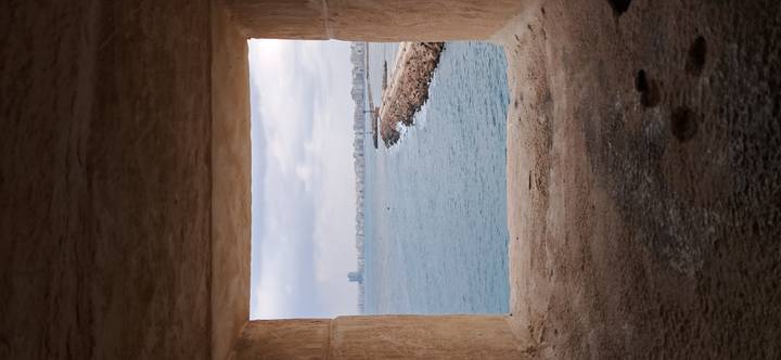 View of a city coastline through a stone window.
