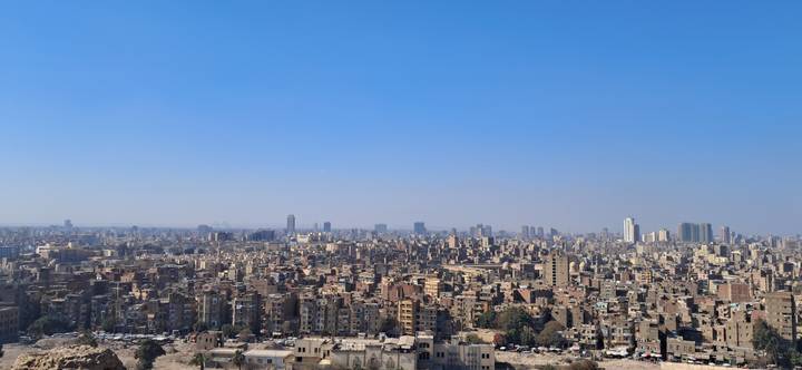 Panoramic view of a sprawling cityscape under a clear blue sky.