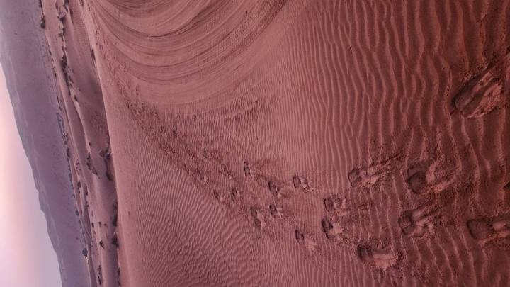 Footprints in the sand on desert dunes.