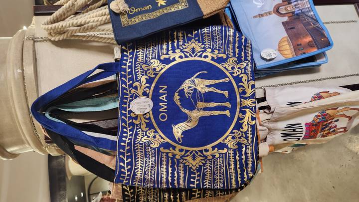 Omani-themed bags for sale in a market.