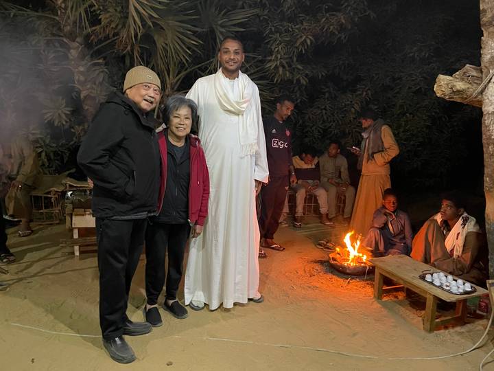 People gathered around a campfire at night.