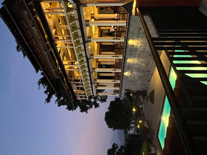 Group sitting by the beach with a beer bottle on a table at sunset.