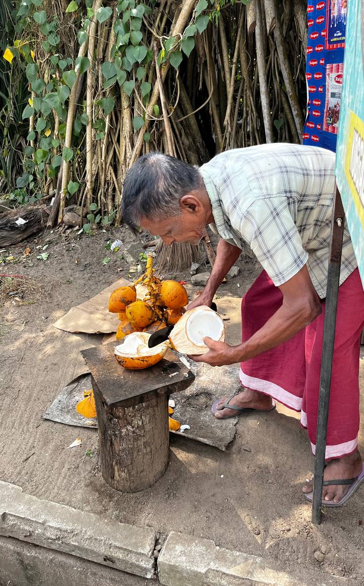 Man preparing coconuts on a street market.