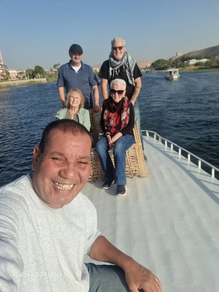 Group sitting on a boat on a river.