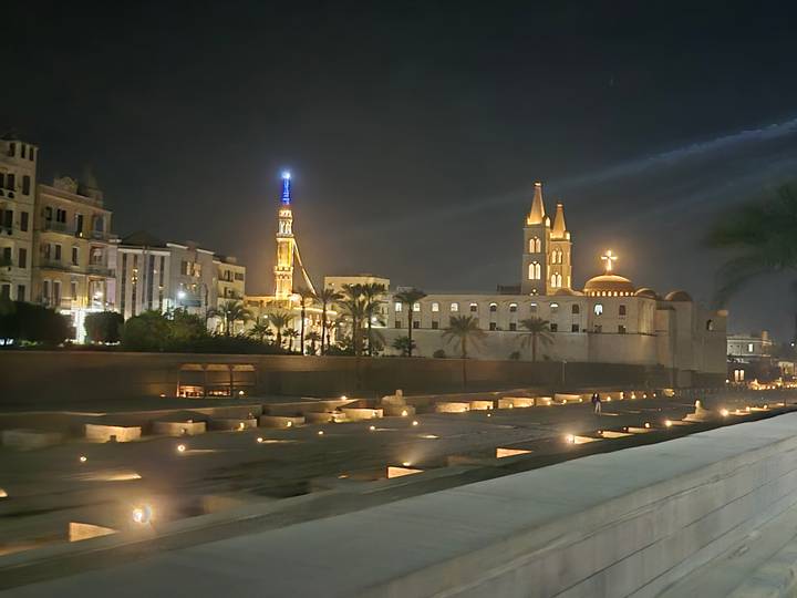 Night view of historic city buildings with lights.