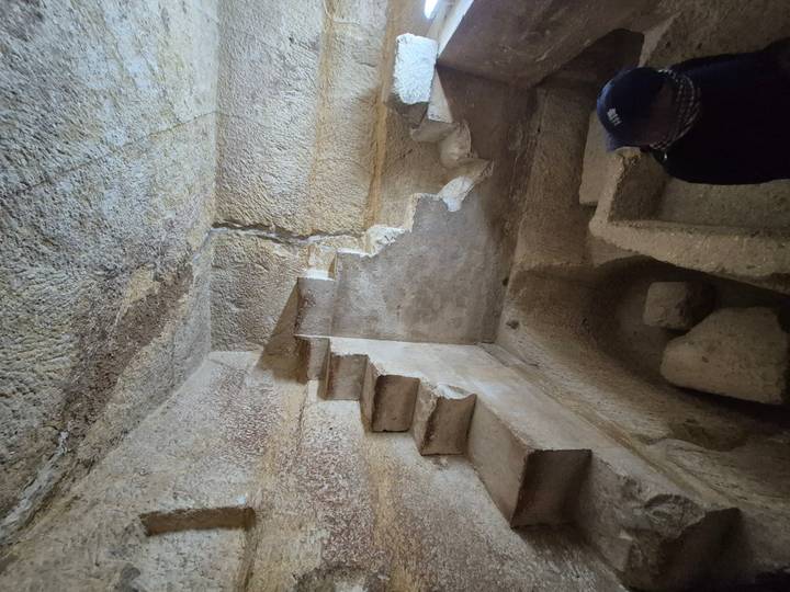 Stone ruins interior with steep stairs.